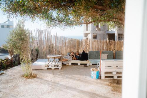 a group of people sitting on benches under a tree at Imsouane surf house in Imsouane