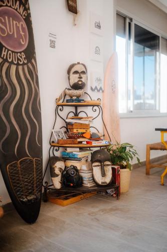 a rack with a surfboard next to a wall at Imsouane surf house in Imsouane