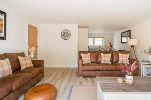 a living room with two brown couches and a table at Upper Oak House in Windermere