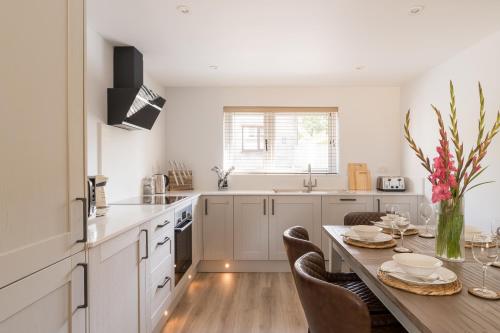 a kitchen with a table with chairs and a dining room at Upper Oak House in Windermere