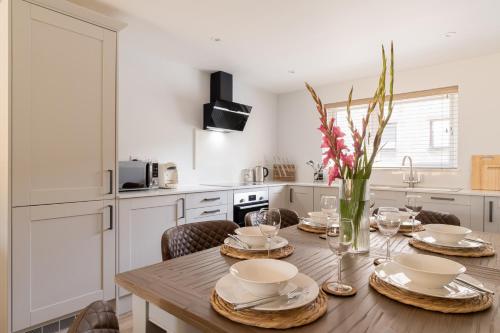 a kitchen with a wooden table with plates and glasses at Upper Oak House in Windermere
