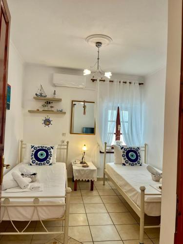 a bedroom with two beds and a table and a window at Kassandra House in Hydra