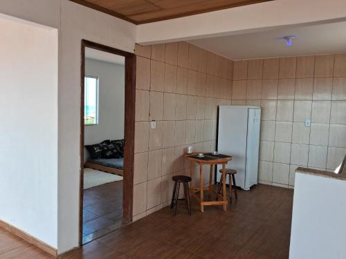 a kitchen with a refrigerator and a table in a room at CABO FRIO, SUITES PÉ AREIA in Cabo Frio