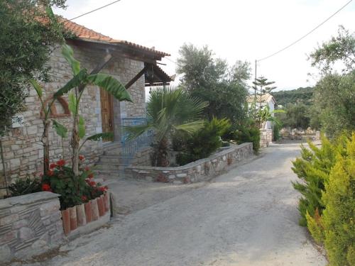 a stone house with a road in front of it at Πέτρινο Σπίτι με Πισίνα in Falánthi