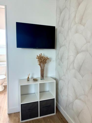 a living room with a tv on a wall at Suite Au grand air in Châteauneuf-du-Faou