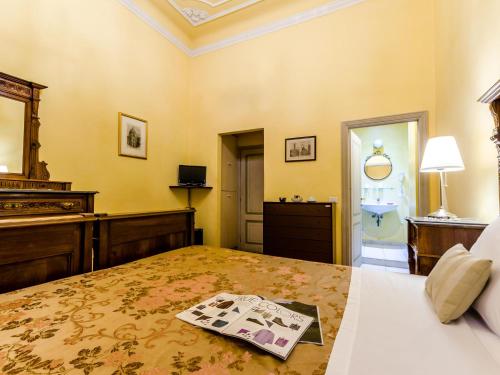 a bedroom with a bed with a magazine on it at Sangaggio House B&B in Florence