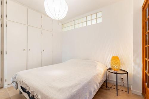 - une chambre blanche avec un lit et une lampe dans l'établissement Marseille bord de mer, à Marseille