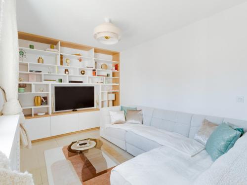 un salon avec un canapé et une télévision dans l'établissement Villa Paradis Urbain, à Colombes
