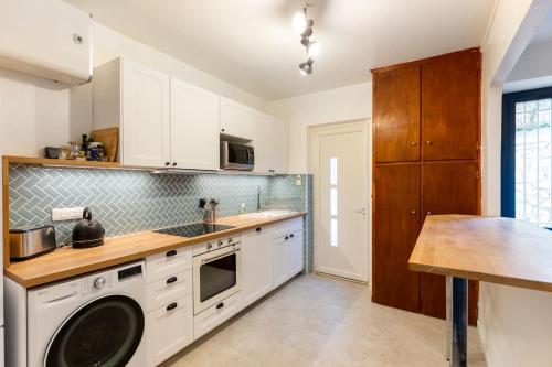 La cuisine est équipée de placards blancs et d'un lave-vaisselle. dans l'établissement Marseille bord de mer, à Marseille