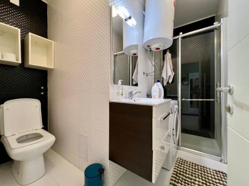 a bathroom with a toilet and a shower and a sink at Blue & Bright Central in Pristina