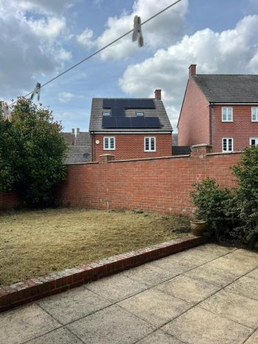 a brick wall in front of a house at Chic 5-bedroom House in Basingstoke with Parking by PureStay in Basingstoke