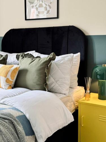 a bedroom with a bed with pillows on it at Chic 5-bedroom House in Basingstoke with Parking by PureStay in Basingstoke