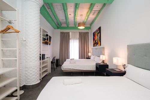 a bedroom with two beds and a green ceiling at Hotel Kuve Marbella in Marbella