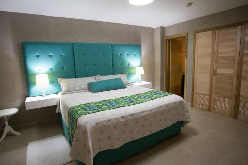 a bedroom with a large bed with a blue headboard at Marbella AquaVista 11-18 in Juan Pedro