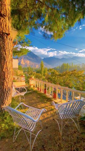 a group of chairs sitting next to a tree at Northlanders Guest House Skardu in Skardu