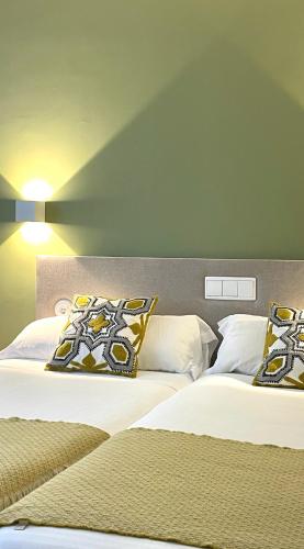 two beds sitting next to each other in a room at Hotel Rosalía in Padrón