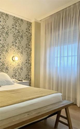 a bedroom with a bed and a window at Hotel Rosalía in Padrón