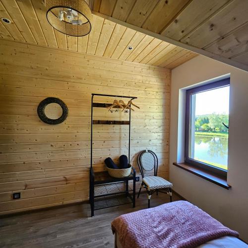 a bedroom with wooden walls and a window and a bed at Przystań nad Sanem z widokiem na góry i rzekę in Tyrawa Solna