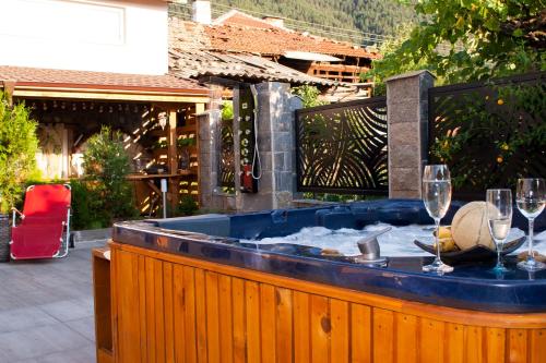 a hot tub with two glasses of wine at Ози 1 Допълнителна къща за гости in Ovchartsi