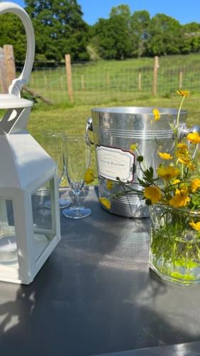 a table with glasses and a vase with flowers on it at The Loft in Stockton on Teme