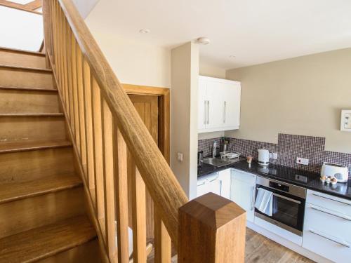 a kitchen with a staircase and a kitchen with a stove at Foxholes Barn in Kidderminster