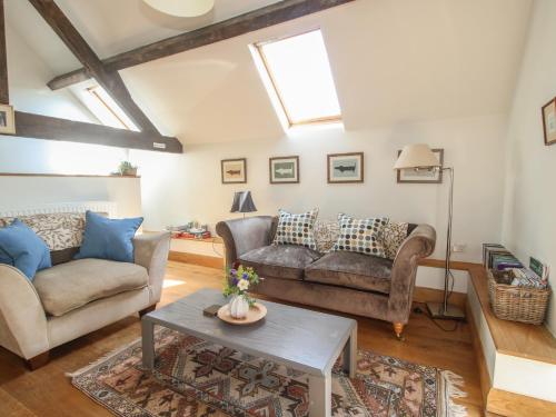 a living room with two couches and a table at Foxholes Barn in Kidderminster