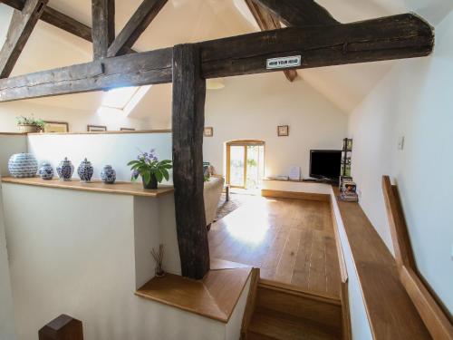 a room with wooden beams and a living room at Foxholes Barn in Kidderminster