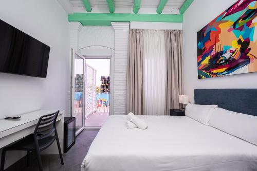 a hotel room with a bed and a desk and a painting at Hotel Kuve Marbella in Marbella