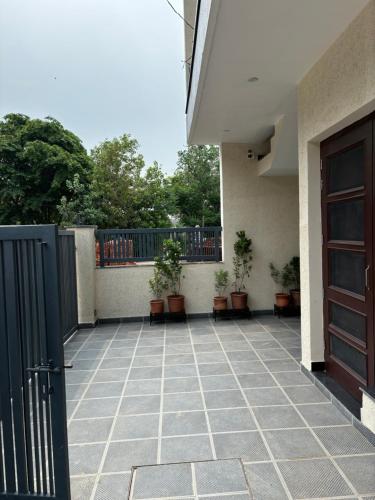 a balcony with a door and potted plants on it at Bhullars villa in Sohāna