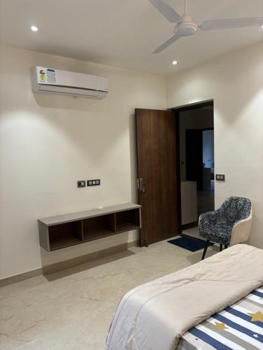 a bedroom with a bed and a chair and a fan at Bhullars villa in Sohāna