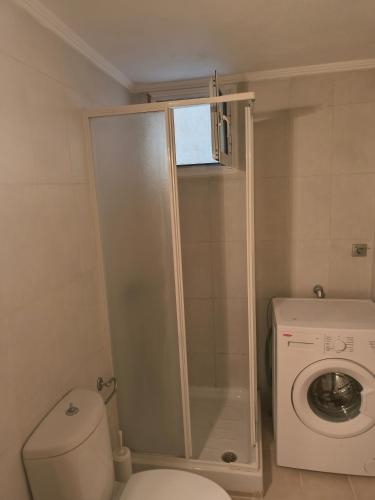 a bathroom with a toilet and a washing machine at marina in Dhidhimótikhon