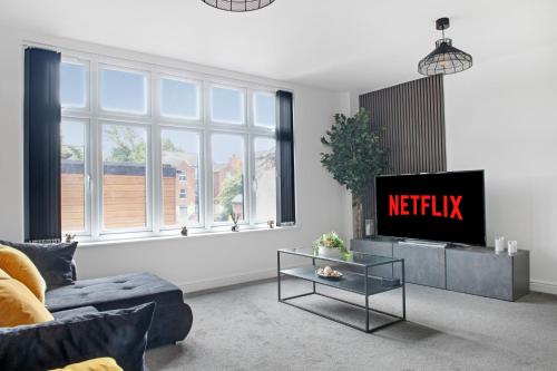 a living room with a couch and a tv at Luxury 2 Bed Apartment in Nottingham City Centre in Nottingham