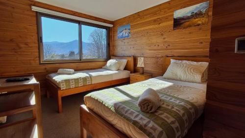 um quarto com 2 camas e uma janela num camarote em Alpes Hotel em Pucón