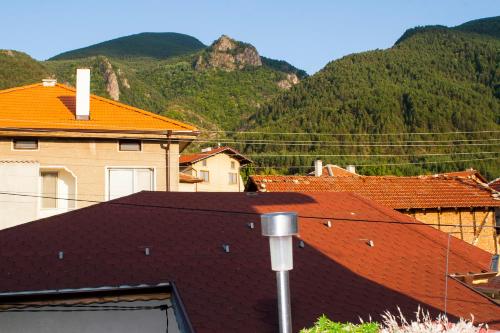 a group of buildings with mountains in the background at Ози 1 Допълнителна къща за гости in Ovchartsi