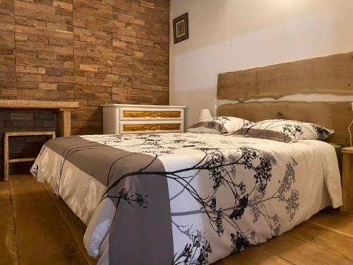 une chambre avec un lit et un mur de briques dans l'établissement Coccon Malmousque, à Marseille