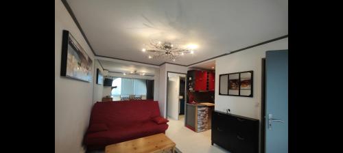 - un salon avec un canapé rouge et un lustre dans l'établissement APPARTEMENT MODERNE prés de la plage avec parking gratuit, à Frontignan