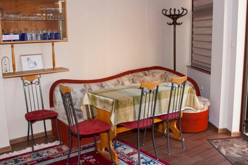 a dining room with a table and four chairs at Ози 1 Допълнителна къща за гости in Ovchartsi