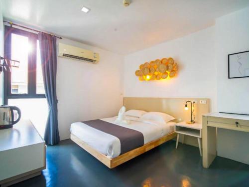 a bedroom with a bed in a room with a window at The Thai Guesthouse and Hostel in Patong Beach