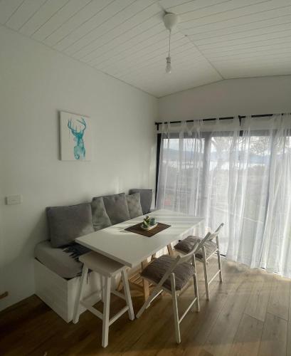 a white table and chairs in a room with a couch at Northglow by REthynk in Jindabyne