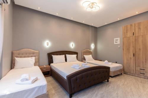 a hotel room with two beds with white sheets at BSP RENT ROOMs in Paralia Sikias