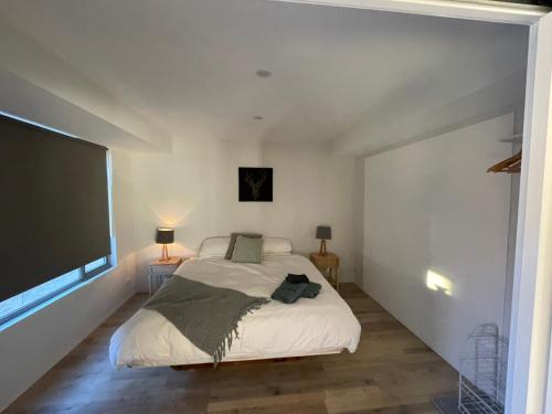 a bedroom with a bed and a flat screen tv at Northglow by REthynk in Jindabyne