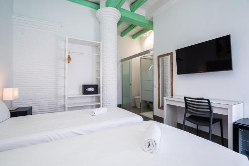 a hotel room with two beds and a tv at Hotel Kuve Marbella in Marbella