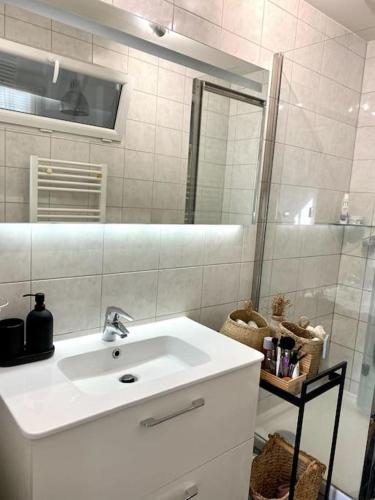 une salle de bain blanche avec un lavabo et une douche dans l'établissement Nice Flat next to Olympic village & Stade de France, à Saint-Ouen