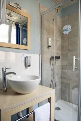une salle de bain avec un lavabo et une douche dans l'établissement Contact Hôtel du Champ de Mars de Saint-Brieuc, à Saint-Brieuc