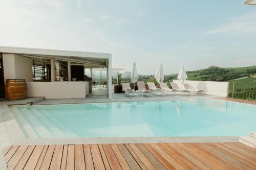 a large swimming pool with chairs and a building at Palas Cerequio in La Morra