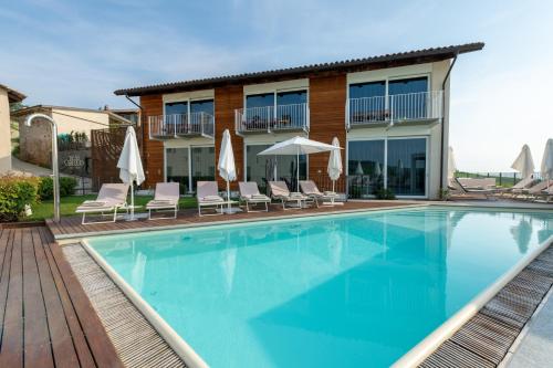 a large swimming pool with chairs and umbrellas at Palas Cerequio in La Morra