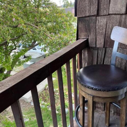 a black stool sitting on a wooden railing on a porch at Mountain View Lodge Cody in Cody