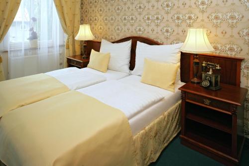 een slaapkamer met een groot bed met 2 witte kussens bij Hotel MERTIN in Chomutov