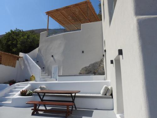 a table and bench on the side of a building at Eolithos Exclusive Suites in Éxo Goniá