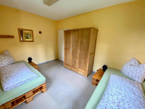 a bedroom with two beds and a wooden cabinet at Ferienwohnung Kolk in Waldsassen
